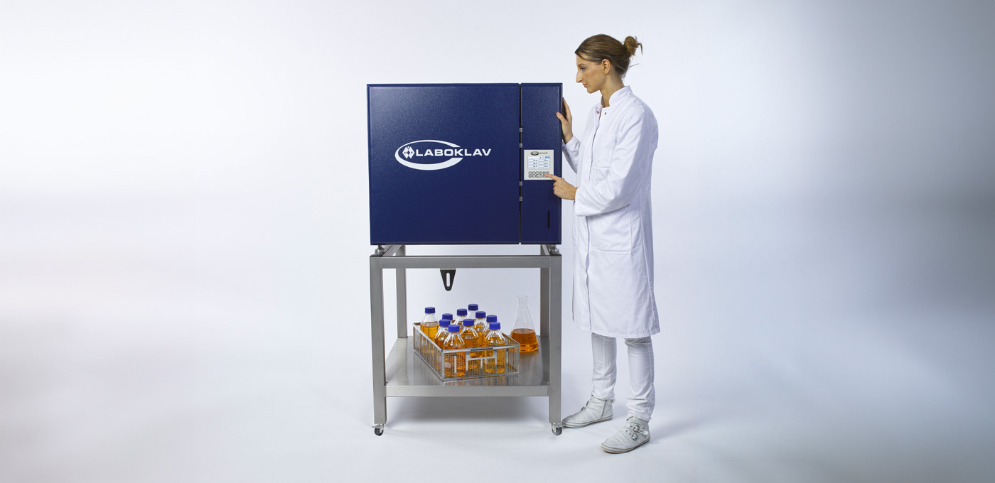 Kobieta obsługuje automat sterylizacyjny Kobieta obsługuje automat sterylizacyjny