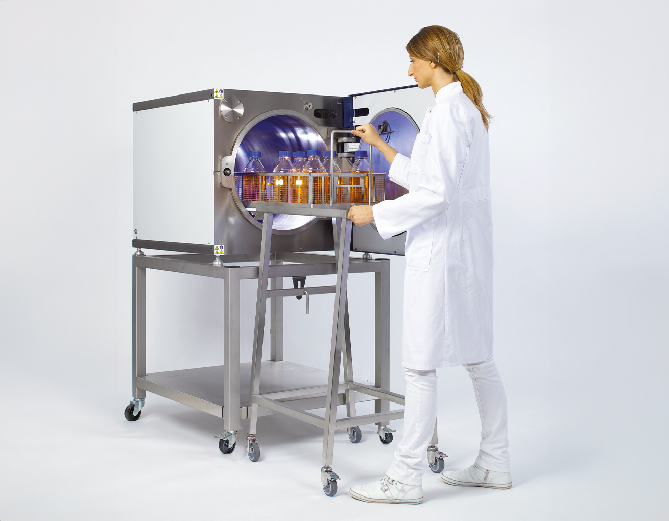 Kobieta obsługuje automat sterylizacyjny Kobieta obsługuje automat sterylizacyjny